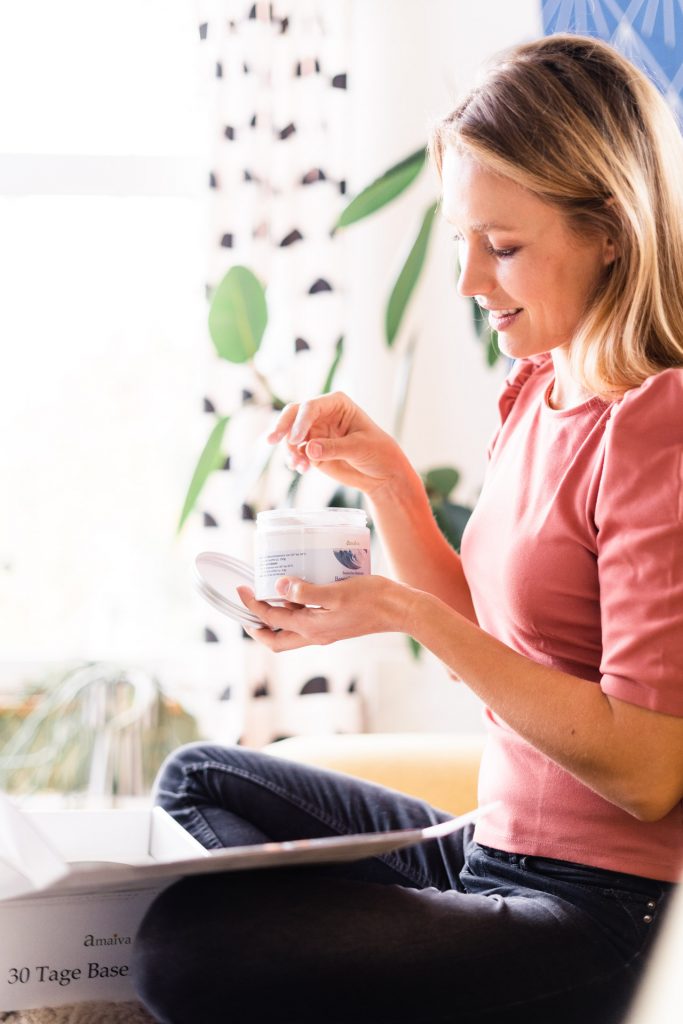 Nahrungsmittelergänzung München Foto Shooting Amaiva Frau hat Salz in Hand sitzt auf Couch