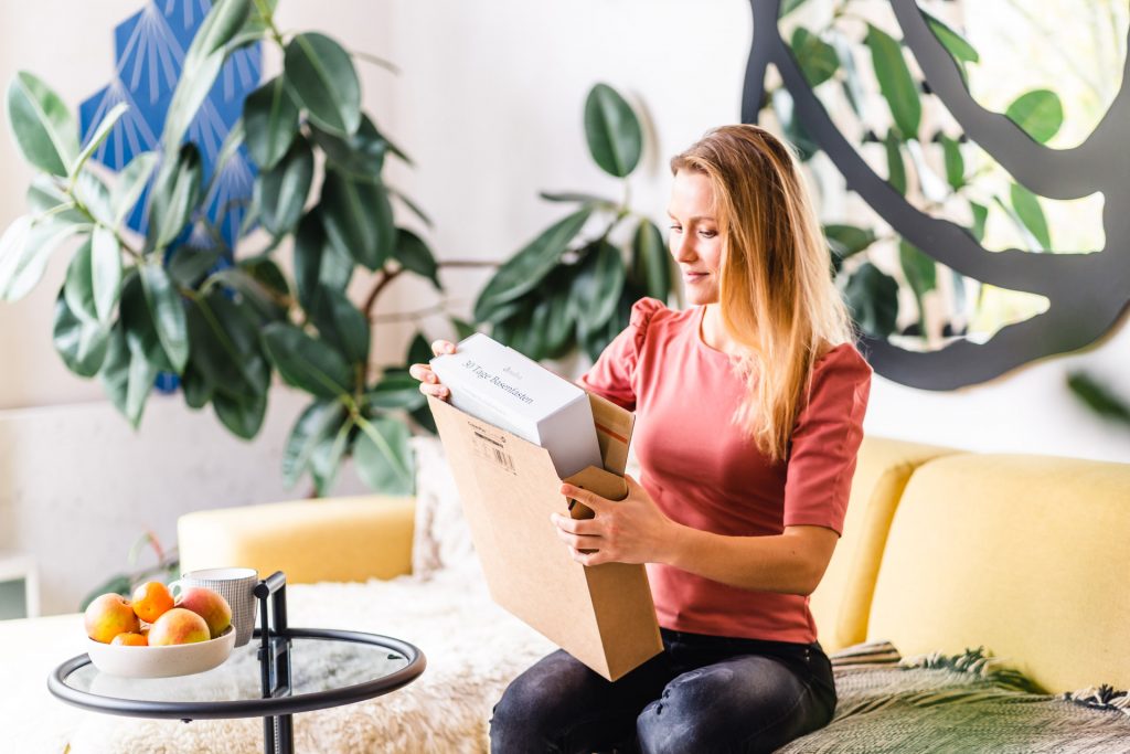 Food Startup München Amaiva Produkt Fotoshooting Food Box Amaiva Frau nimmt Box in Hand