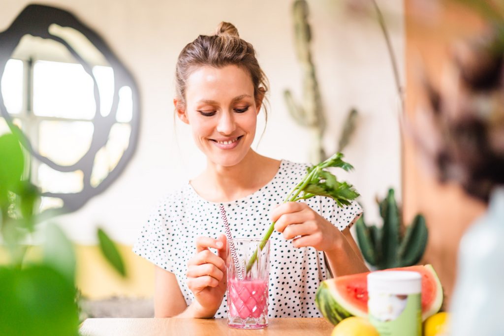 Frau lacht mit Flasche in Hand Sommer Melone Foto Shooting moderne Wohnung Milkshake