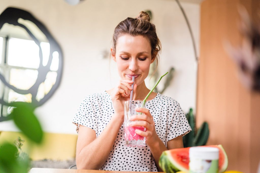 Frau lacht mit Flasche in Hand Sommer Melone Foto Shooting moderne Wohnung