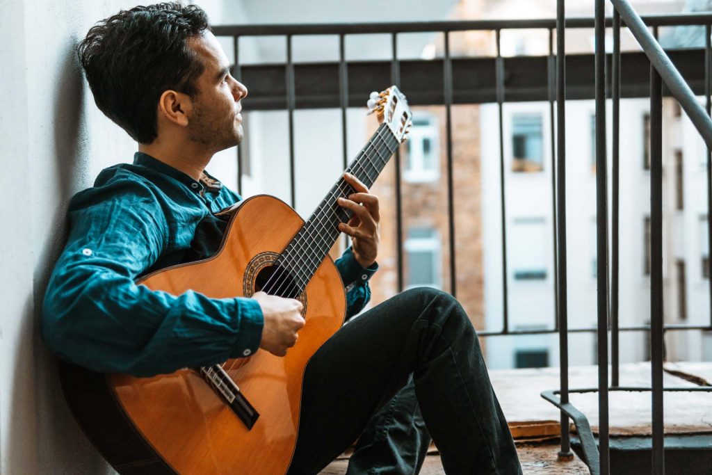 Gitarrist sitzt mit Gitarre auf Treppe vor Loft in Frankfurt für Scorepad Produkt Foto Shooting