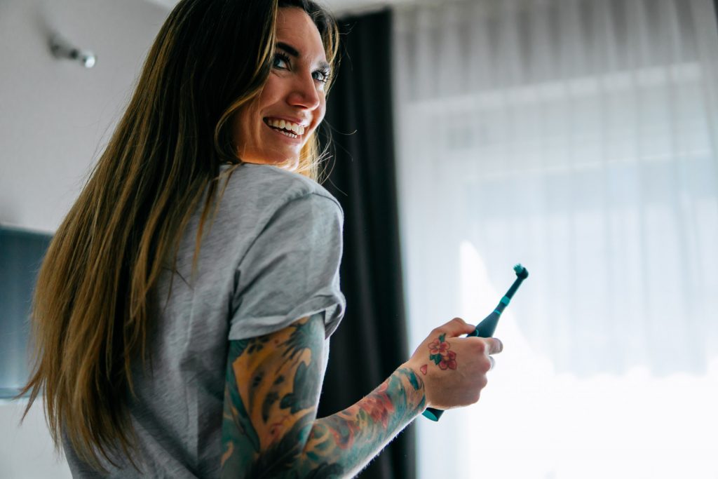 Lifestyle Fotoshooting Happybrush Frau lacht mit elektrischer Zahnbürste Produkt Fotoshooting