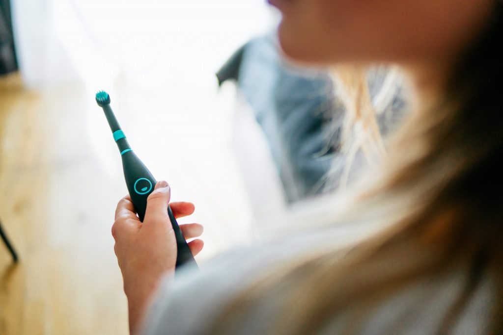 Lifestyle Fotoshooting Happybrush Frau lacht mit elektrischer Zahnbürste Produkt Fotoshooting