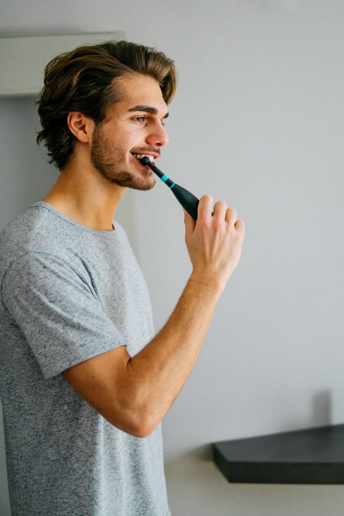 Mann putzt Zähne mit Happybrush elektrischer Zahnbürste Fotoshooting München Produkt