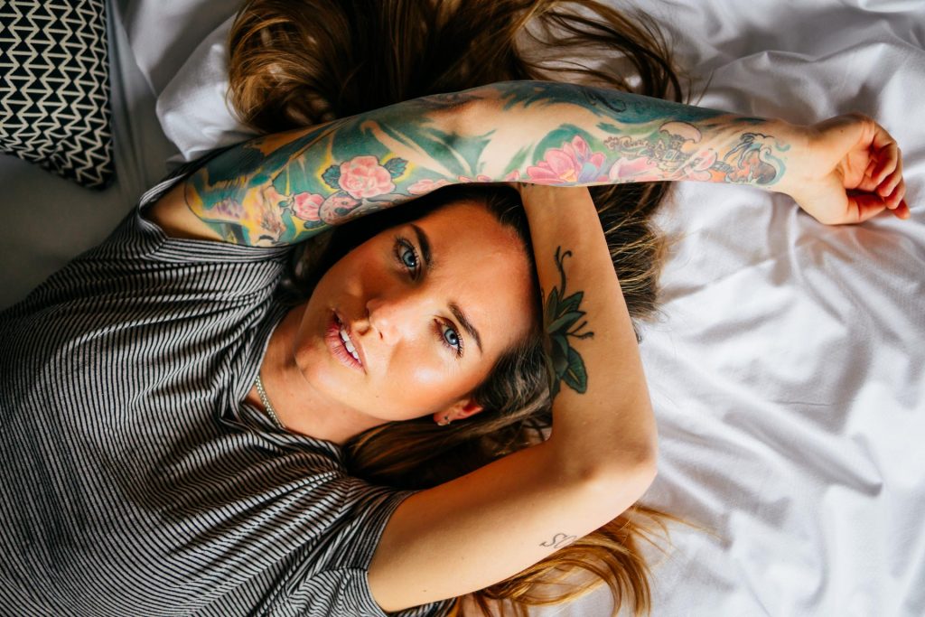 Model lacht in Bett bei Produkt Fotoshooting