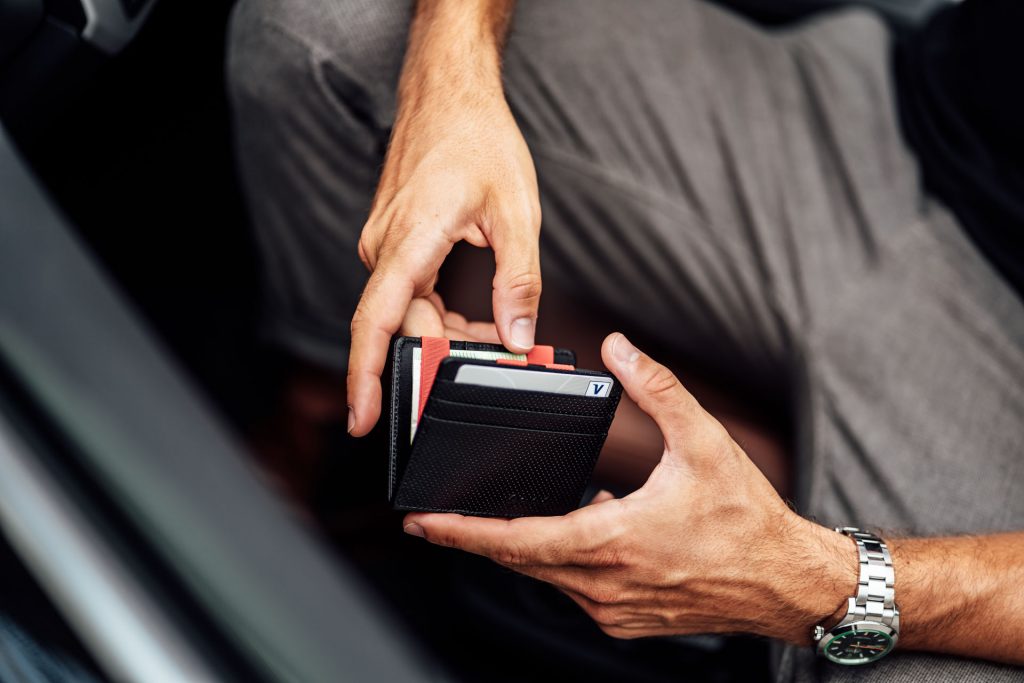 Produkt Fotoshooting München Geldbeutel Street Photography Startup Mann sitzt in Auto mit Geldbeutel