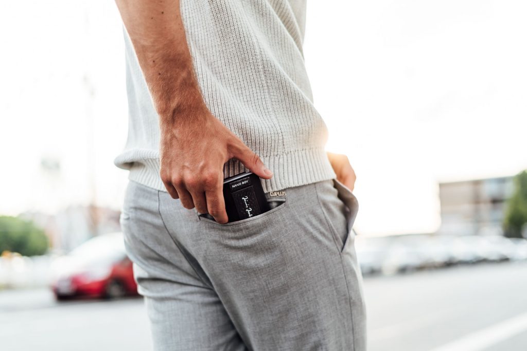 Mann lehnt an Wand Portrait München Produkt Fotoshooting München steckt Geldbeutel in Hose
