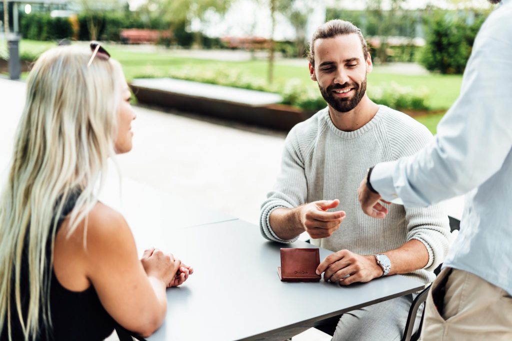 Commercial Fotograf München Paar zahlt mit Geldbeutel Kellner