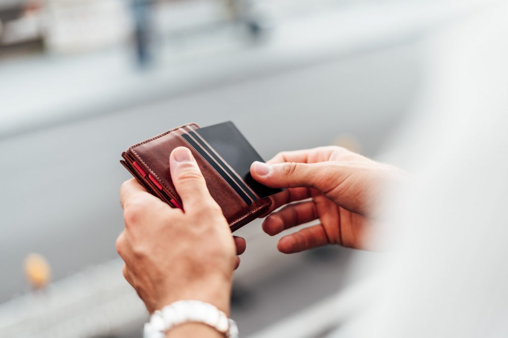 Produkt Shooting München Commercial Fotograf Mann hält Geldbeutel in Hand