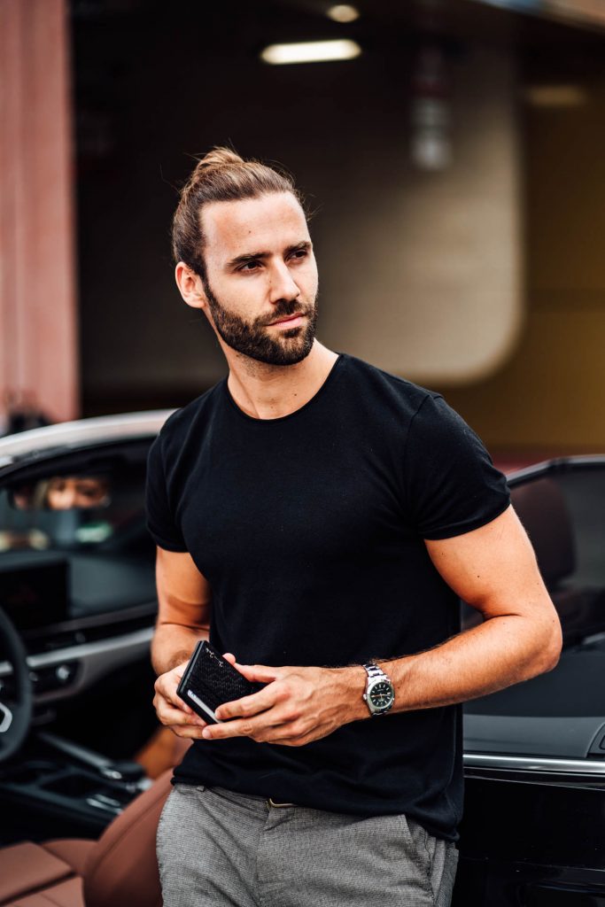 Produkt Fotoshooting München Geldbeutel Street Photography Startup Mann sitzt in Auto mit Geldbeutel